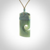 New Zealand jade toki koru pendant. Hand carved in New Zealand. Hand made New Zealand Jade jewellery. Provided with an adjustable cord and packaged in a woven kete pouch.